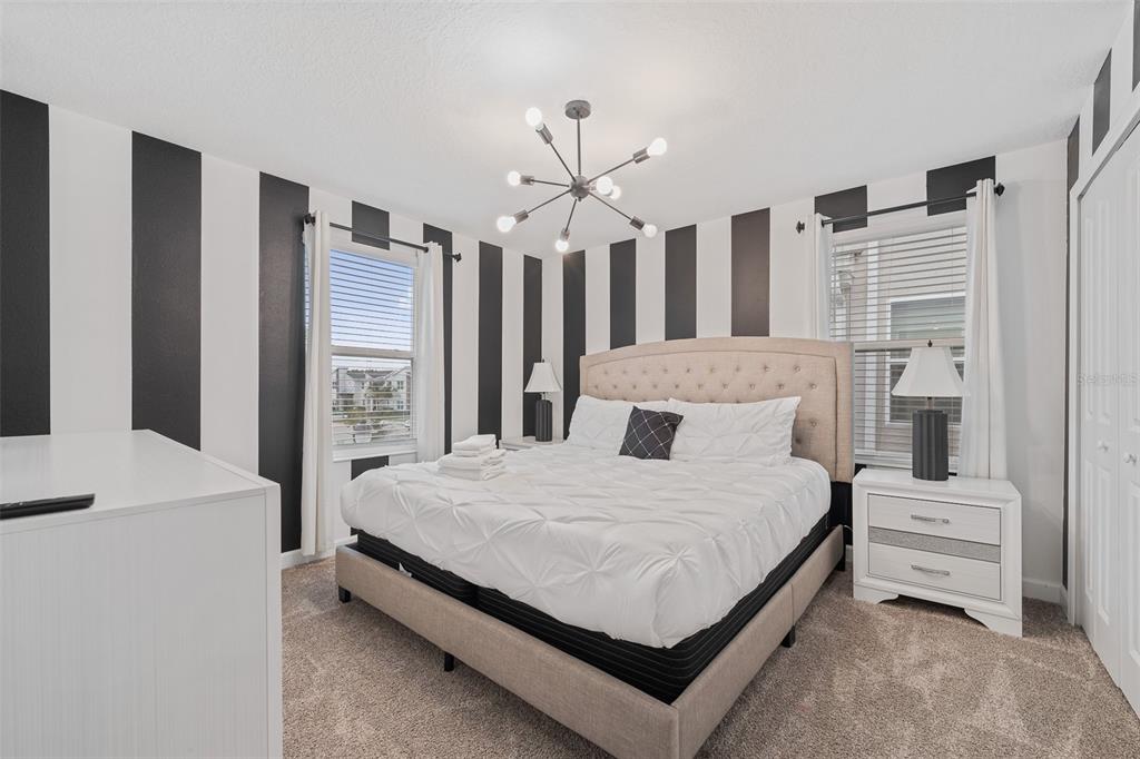 3000 Penelope Loop Kissimmee, FL 34746 - Photo 38 of 53 a bedroom with a large bed and a chandelier