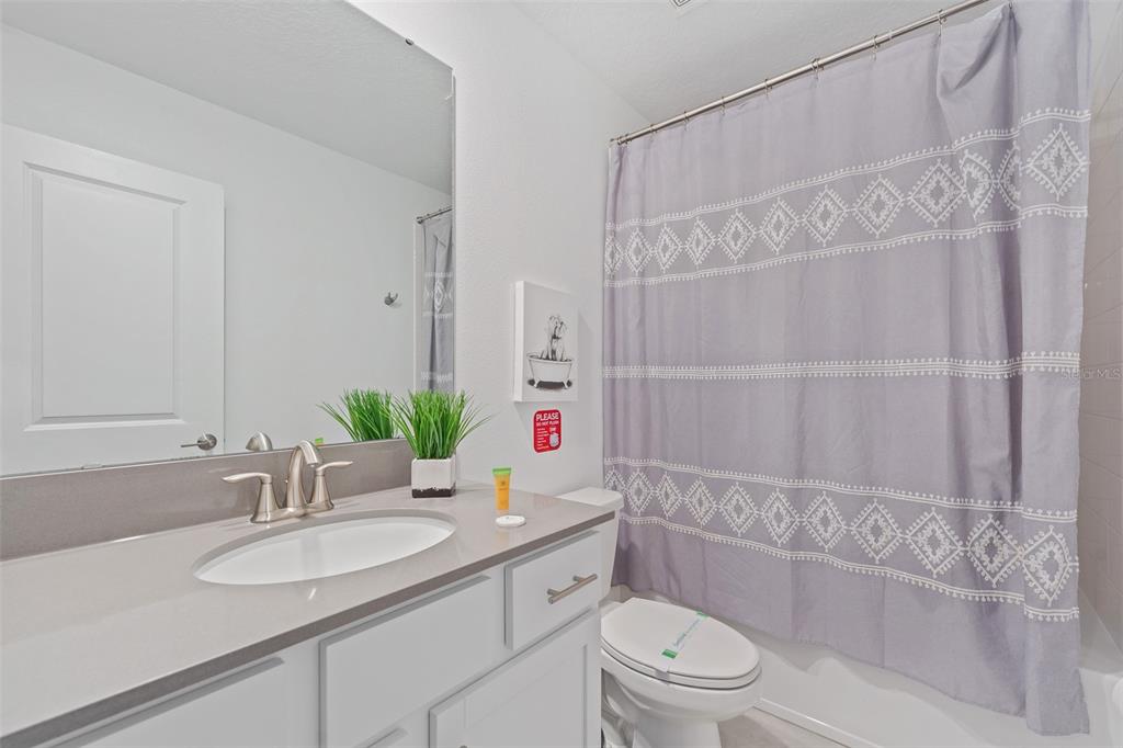 3000 Penelope Loop Kissimmee, FL 34746 - Photo 41 of 53 a bathroom with a granite countertop sink a toilet and shower