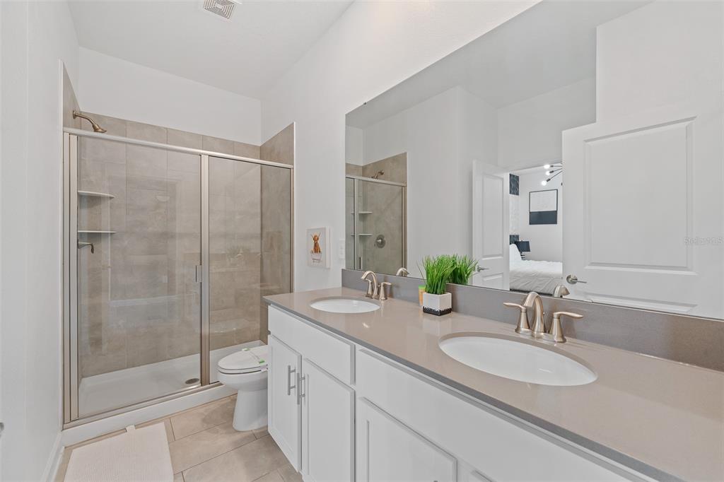 3000 Penelope Loop Kissimmee, FL 34746 - Photo 7 of 53 a bathroom with a double vanity sink toilet and shower