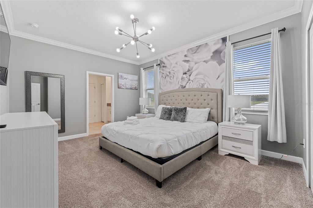3000 Penelope Loop Kissimmee, FL 34746 - Photo 10 of 53 a spacious bedroom with a bed and a chandelier