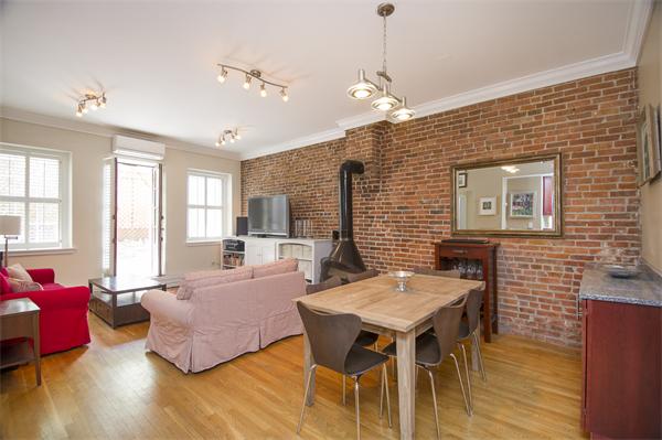 116 Charles Street, Unit 1 Boston, MA 02114 - Photo 2 of 8 a living room with furniture a dining table and a chandelier