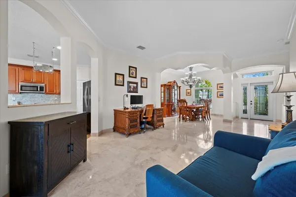 a living room with furniture kitchen view and a large window