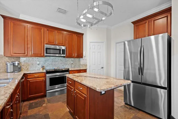 a kitchen with stainless steel appliances granite countertop a refrigerator a stove sink and microwave