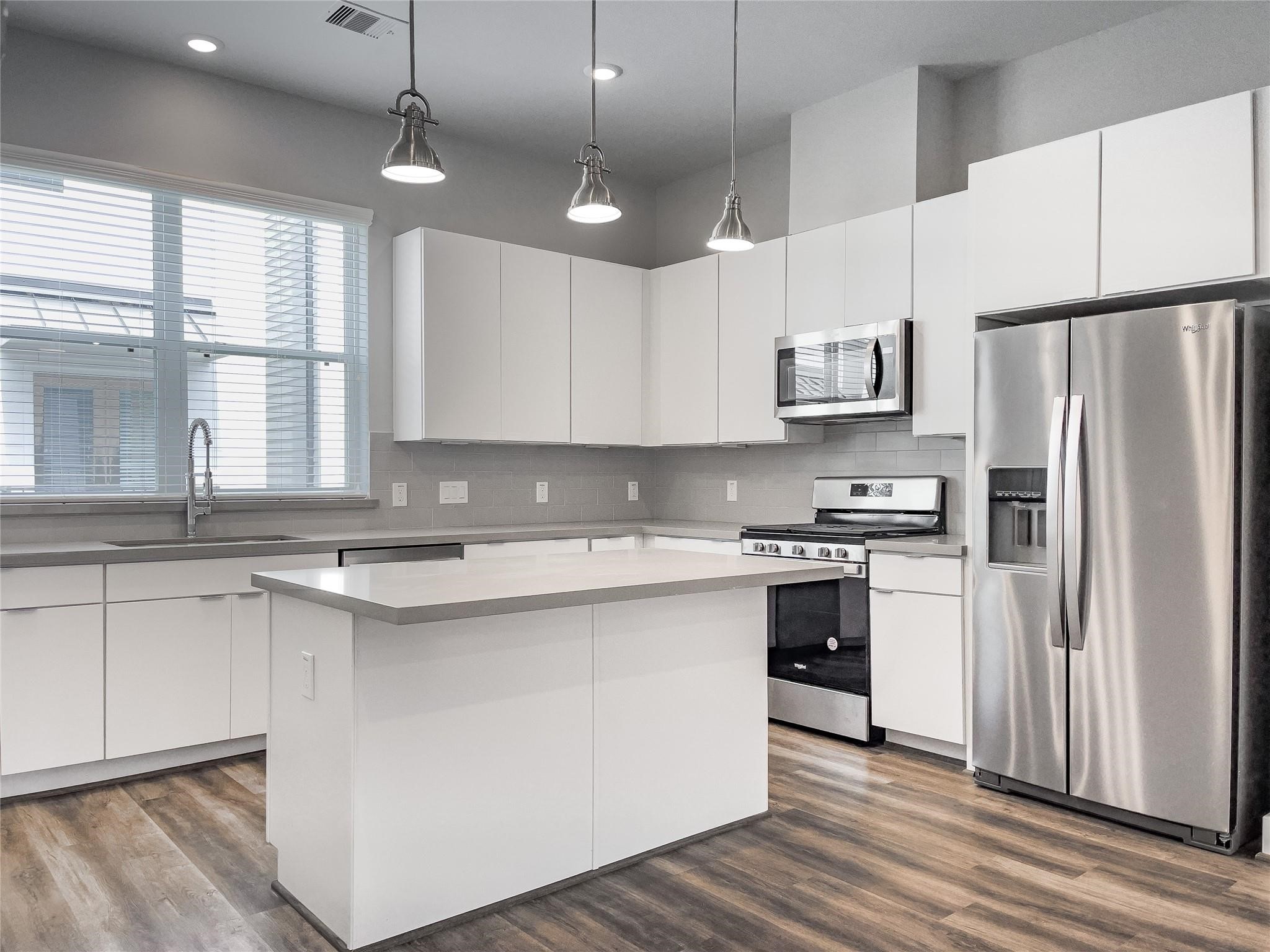 a kitchen with stainless steel appliances a refrigerator a sink and a stove