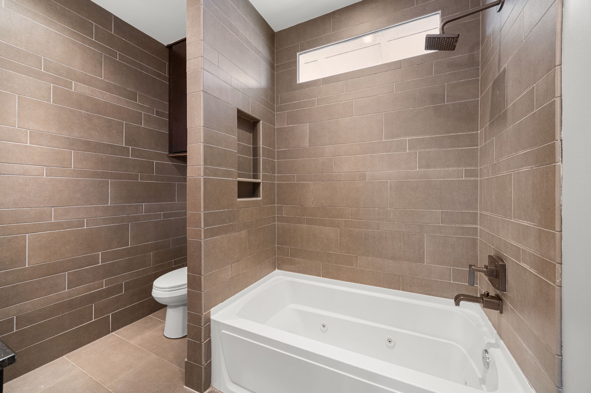 1115 Adele Street Houston, TX 77009 - Photo 12 of 19 Full bathroom featuring tile surround, soaking tub, and built-in shower niche.