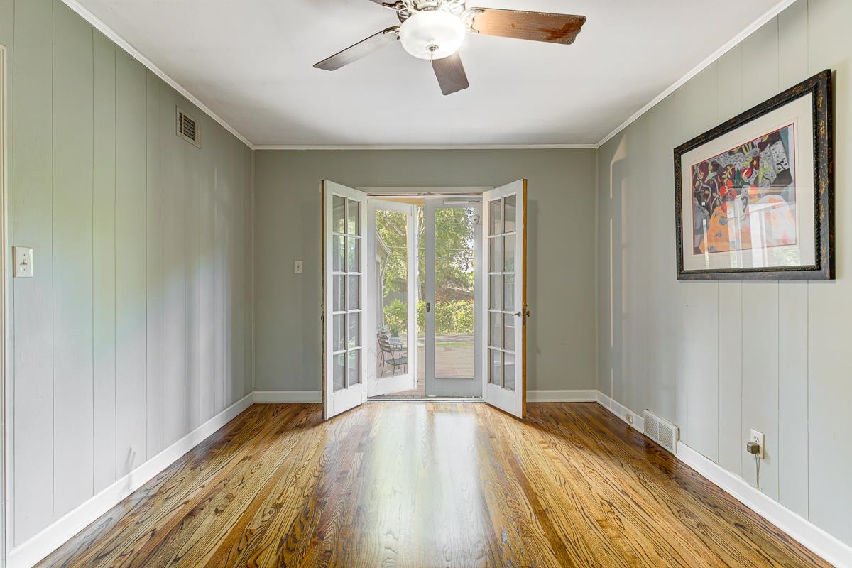 5676 Barfield Road Memphis, TN 38120 - Photo 10 of 19 Spacious room featuring rich wood-finish flooring, light green paneled walls, and white trim