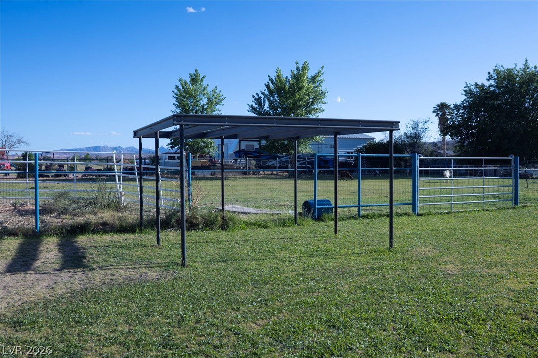 2775 Taylor Street Logandale, NV 89021 - Photo 38 of 41 This expansive yard features a covered structure and secure fencing, perfect for outdoor activities.