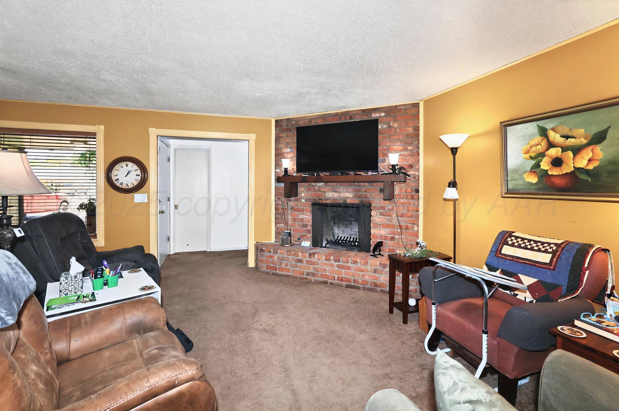 6005 Gainsborough Road Amarillo, TX 79106 - Photo 2 of 19 a living room with furniture a flat screen tv and a fireplace