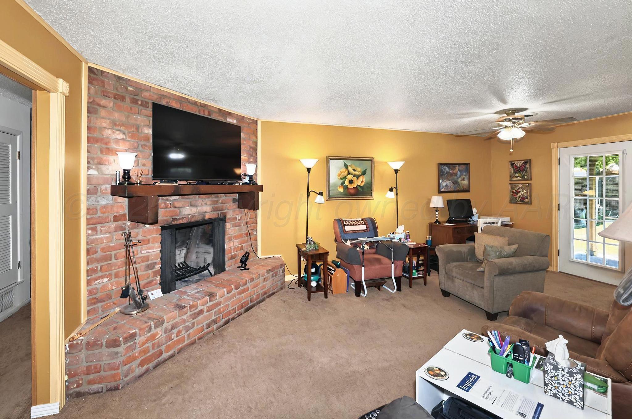 6005 Gainsborough Road Amarillo, TX 79106 - Photo 3 of 19 a living room with furniture a flat screen tv and a fireplace