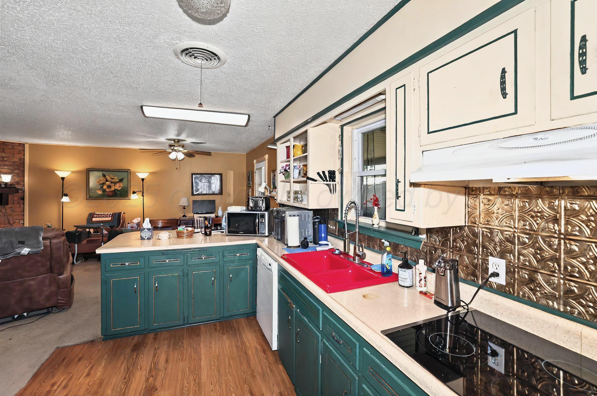 6005 Gainsborough Road Amarillo, TX 79106 - Photo 6 of 19 a kitchen that has a lot of cabinets and wooden floor