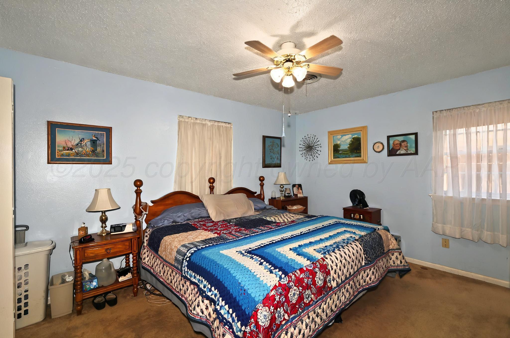6005 Gainsborough Road Amarillo, TX 79106 - Photo 8 of 19 a bed room with a bed and a chandelier