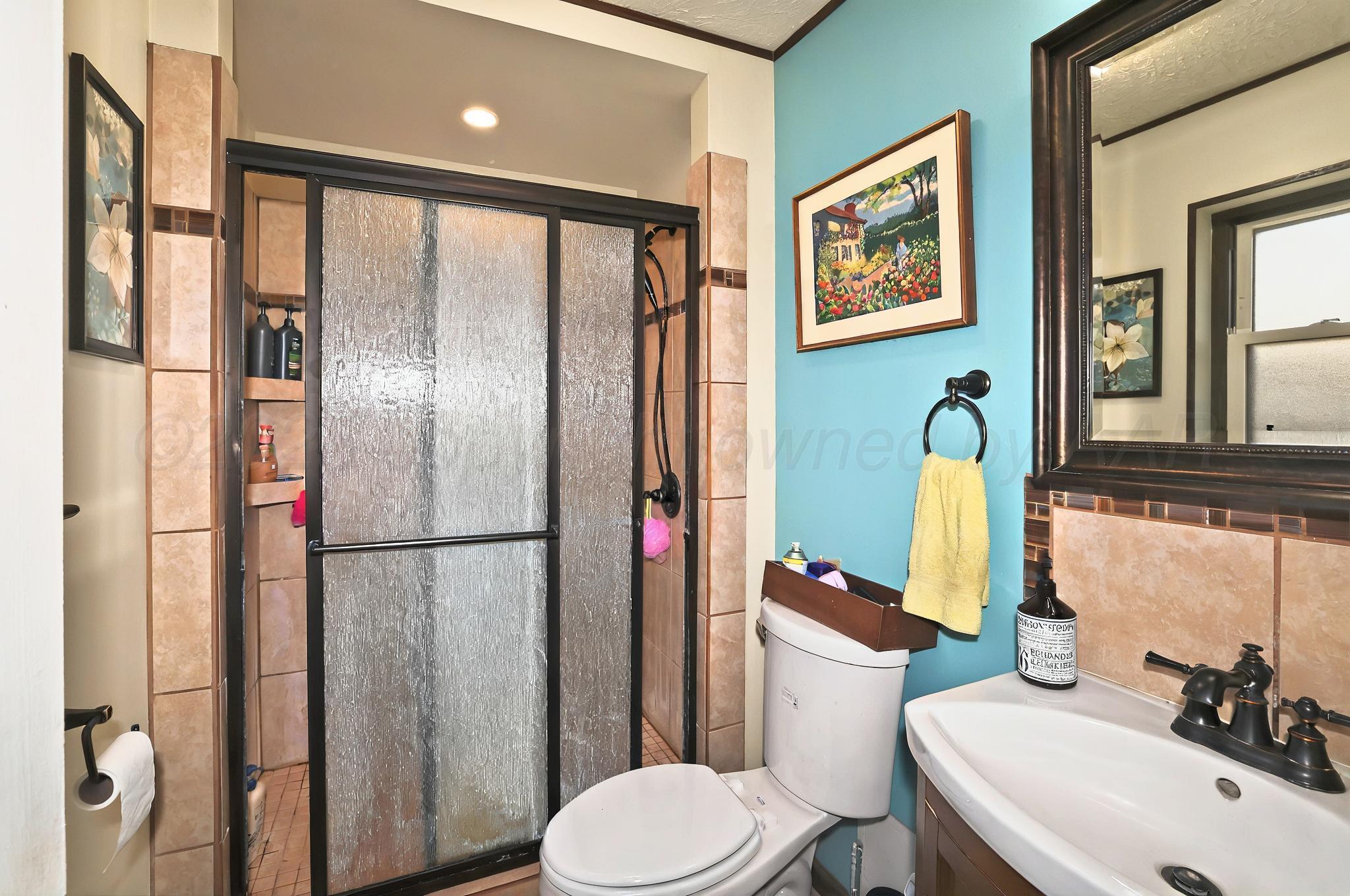 6005 Gainsborough Road Amarillo, TX 79106 - Photo 10 of 19 a bathroom with a sink toilet and shower