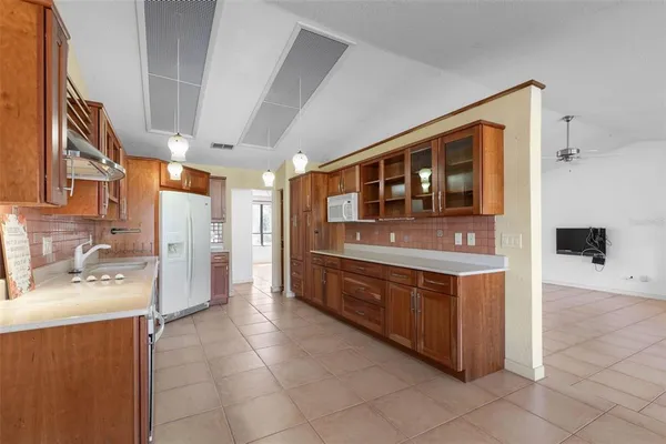 a hallway with stainless steel appliances granite countertop a refrigerator and cabinets