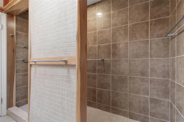 a spacious bathroom with a double vanity sink a mirror and a shower