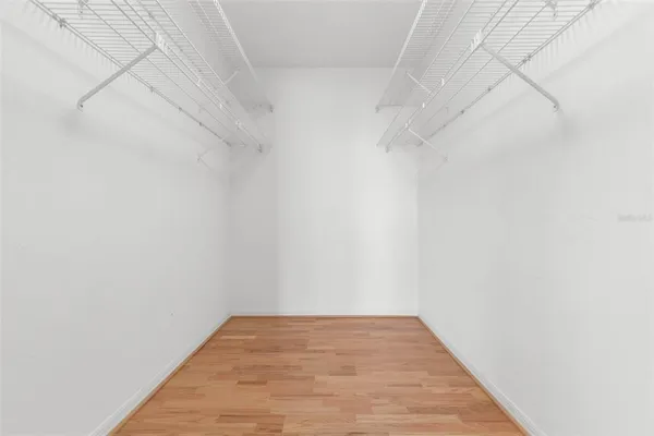 an empty room with wooden floor & closet area