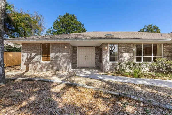 a view of an empty room with window and chandelier