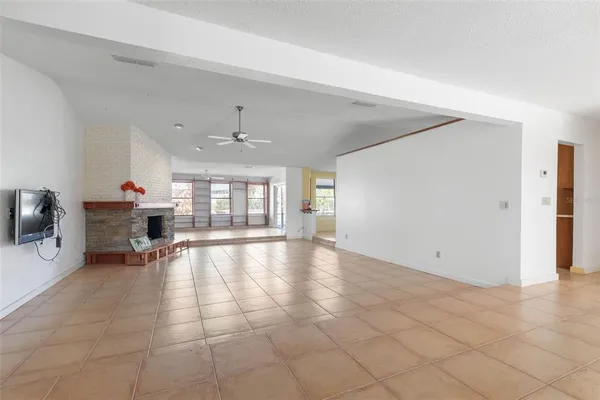 a view of an empty room with window and fireplace