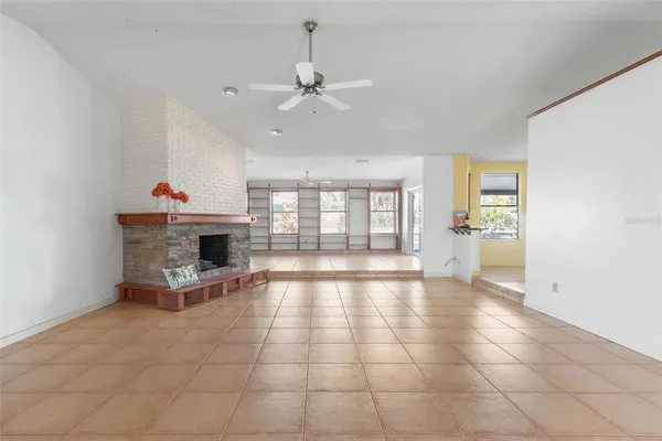 a view of an empty room with a fireplace and a window