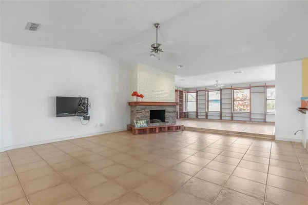 a view of an empty room with a fireplace and a window