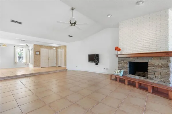a living room with fireplace furniture and a potted plant