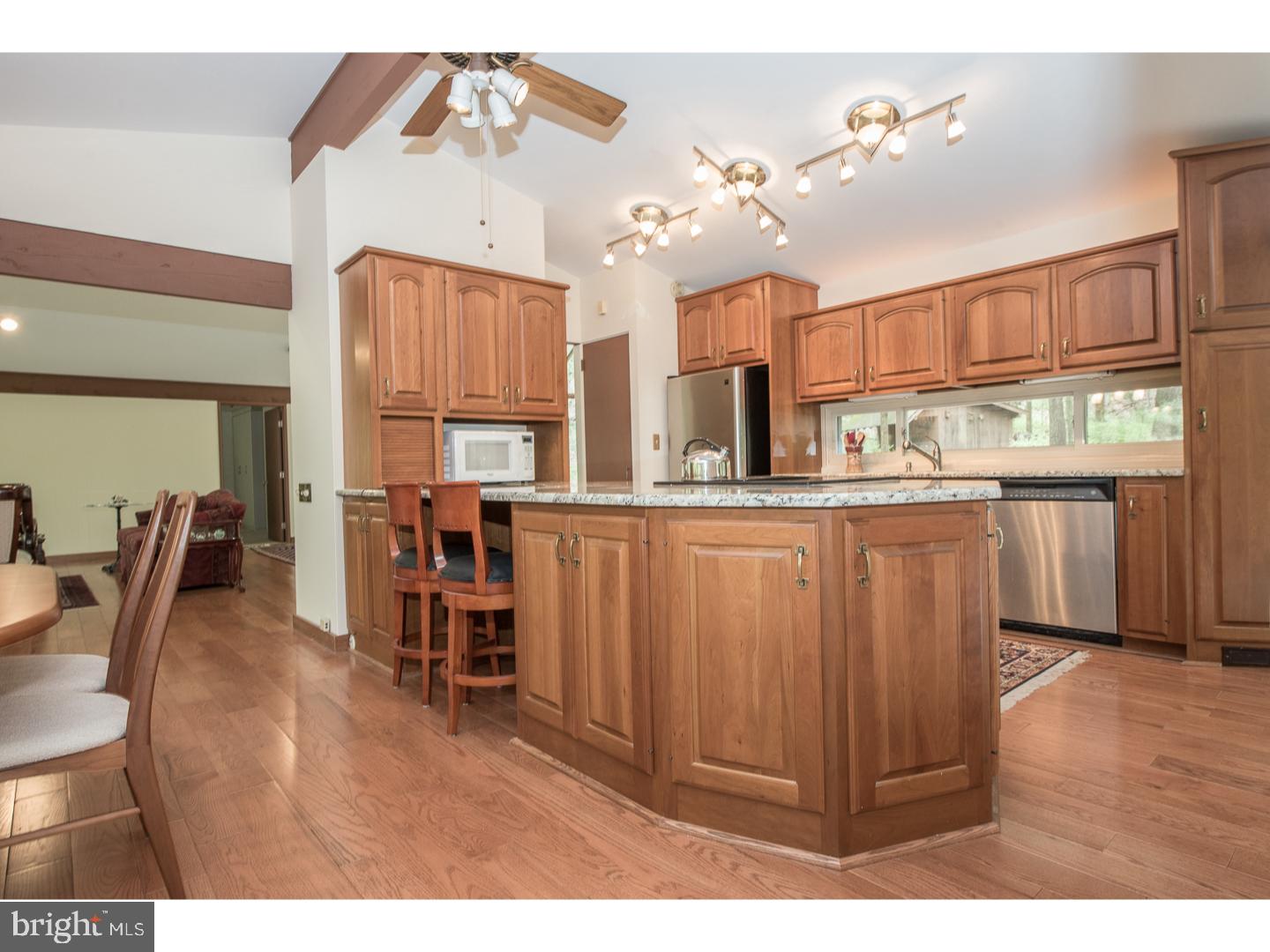 597 Upper Weadley Road Wayne, PA 19087 - Photo 6 of 25 a kitchen with stainless steel appliances kitchen island granite countertop a table chairs and a refrigerator