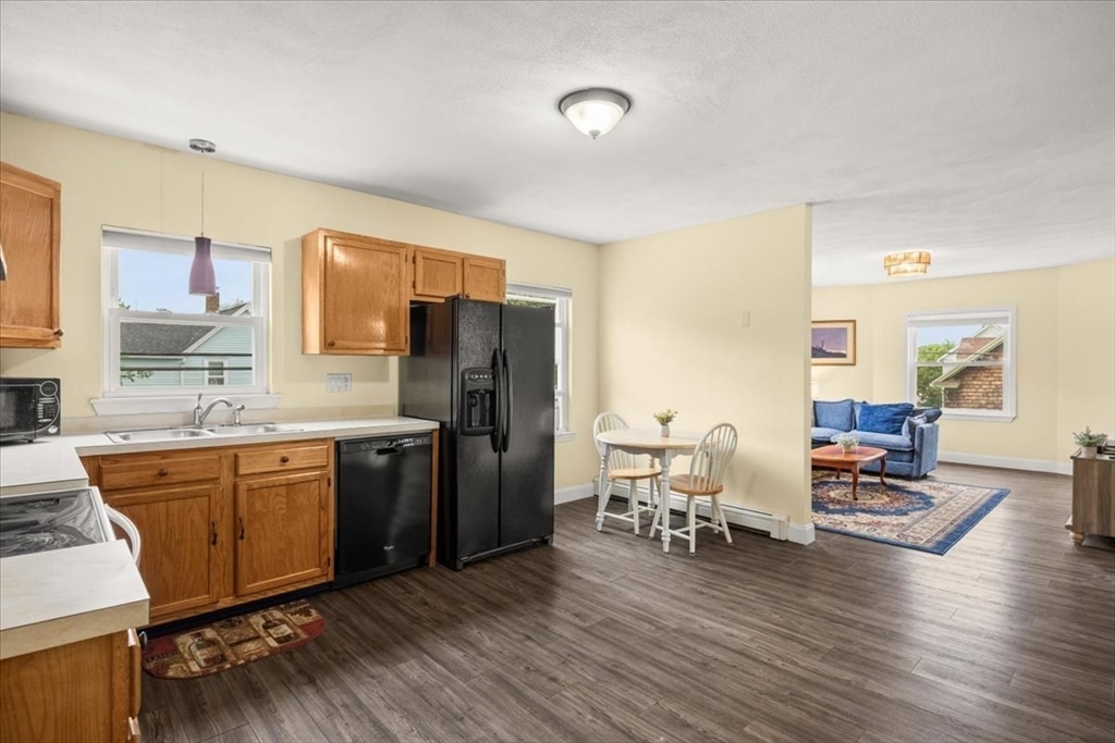 35 Hazel Street, Unit B Attleboro, MA 02703 - Photo 5 of 21 a kitchen with stainless steel appliances granite countertop a refrigerator a stove top oven a dining table and chairs with wooden floor