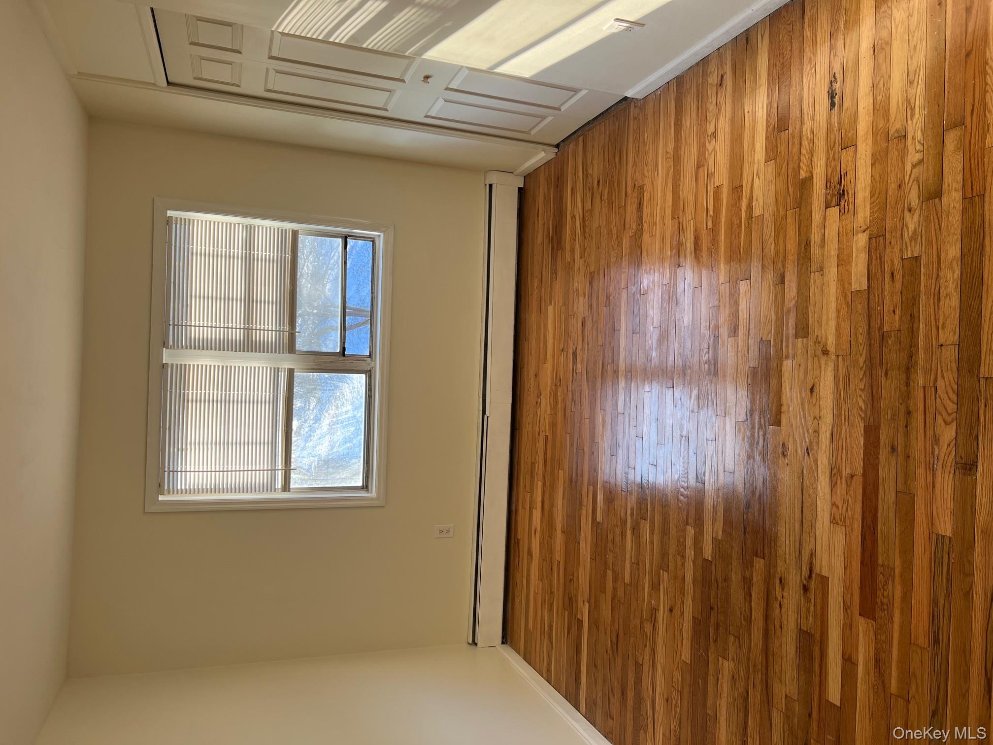 2103 Barclay Manor, Unit 21C Newburgh, NY 12550 - Photo 5 of 7 a view of an empty room with wooden floor and a window