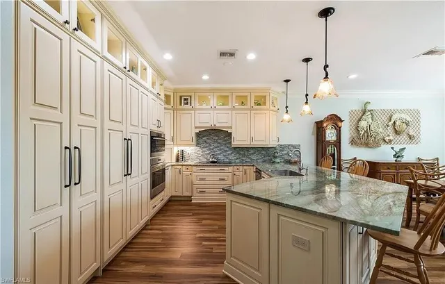 a kitchen with stainless steel appliances granite countertop a stove a sink and a refrigerator