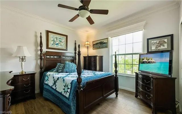 a bedroom with a bed and a tv on the wall