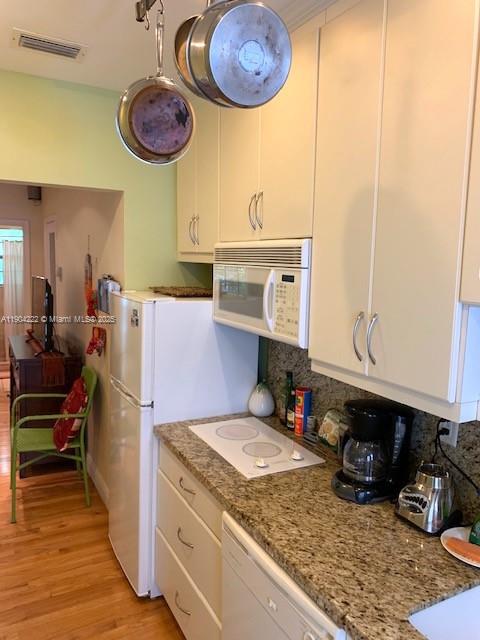 744 Lenox Avenue, Unit 3 Miami Beach, FL 33139 - Photo 5 of 13 a kitchen with a refrigerator and a stove top oven