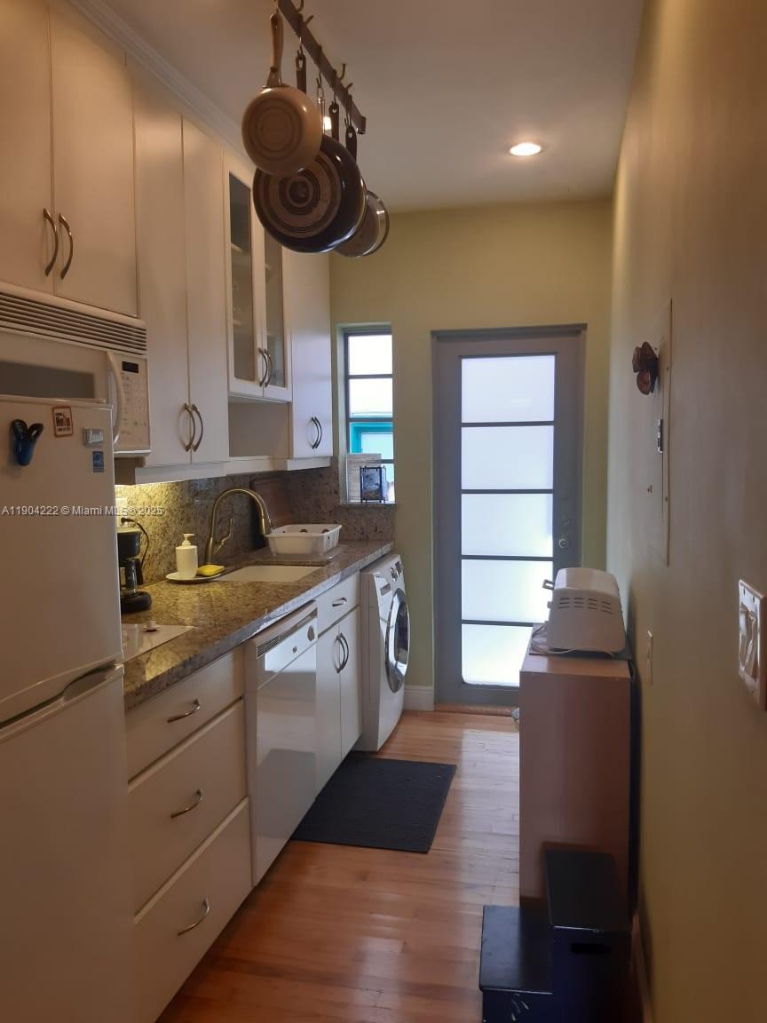 744 Lenox Avenue, Unit 3 Miami Beach, FL 33139 - Photo 6 of 13 a kitchen with stainless steel appliances granite countertop a sink and dishwasher with wooden floor