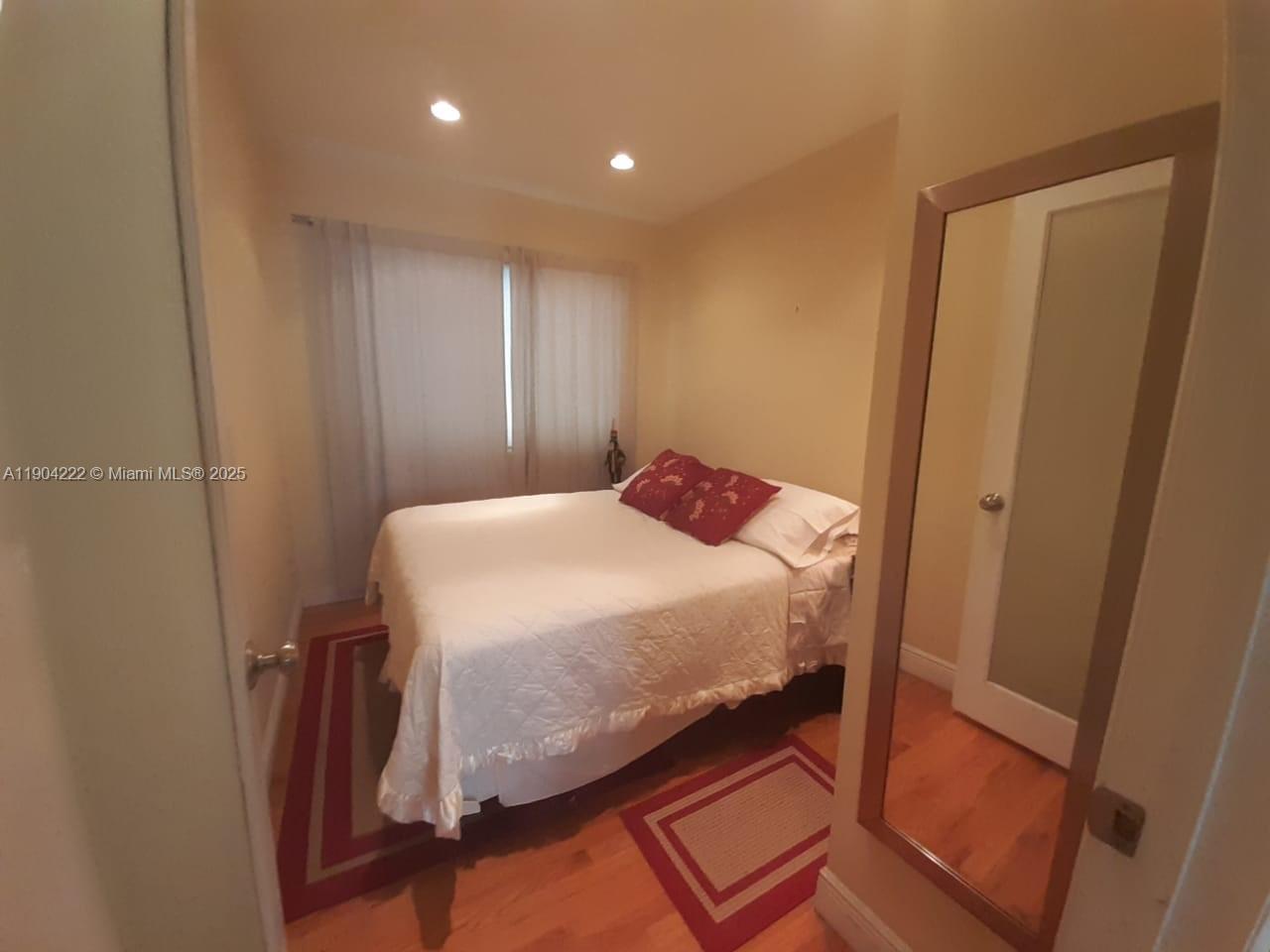 744 Lenox Avenue, Unit 3 Miami Beach, FL 33139 - Photo 7 of 13 a bedroom with a bed and a mirror