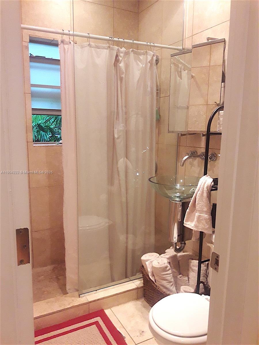 744 Lenox Avenue, Unit 3 Miami Beach, FL 33139 - Photo 8 of 13 a bathroom with a shower curtain