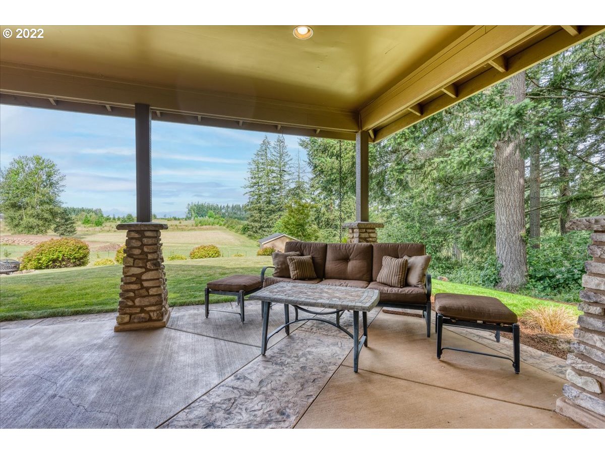 18809 South Kimball Road Oregon City, OR 97045 - Photo 4 of 32 a view of a patio with a table chairs and a backyard