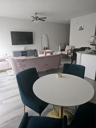 a living room with furniture a flat screen tv and kitchen view