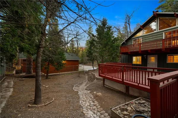 a view of a house with a yard and wooden fence