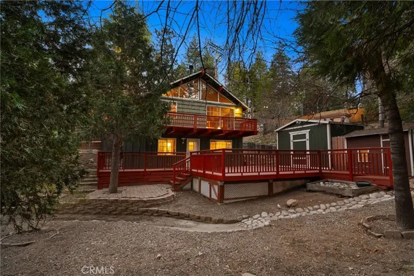 a balcony with wooden floor and trees in the background