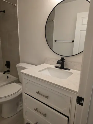 a bathroom with a sink a toilet and a mirror