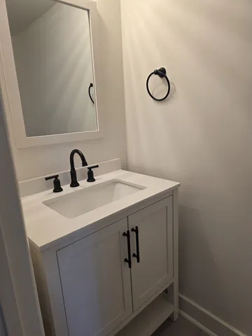 a bathroom with a sink and vanity with a mirror