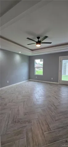 an empty room with windows and fan