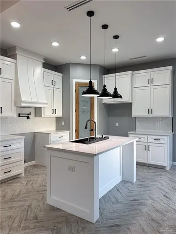 a kitchen with kitchen island a sink stainless steel appliances and cabinets