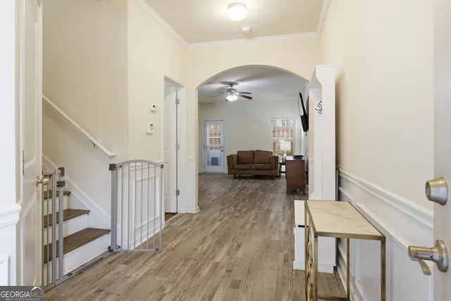 a view of a hallway with wooden floor and staircase