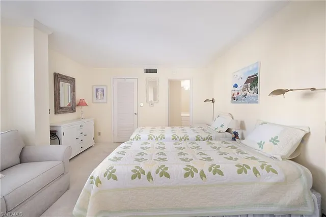 a bed sitting in a bedroom and chandelier