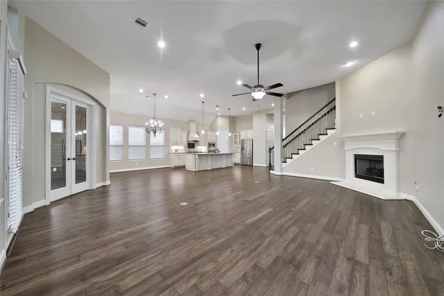 a view of an empty room with wooden floor fireplace and a window