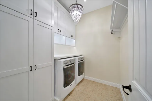 a view of an empty room and chandelier fan