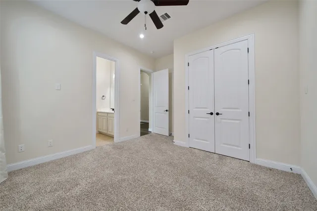 an empty room with a ceiling fan and a window