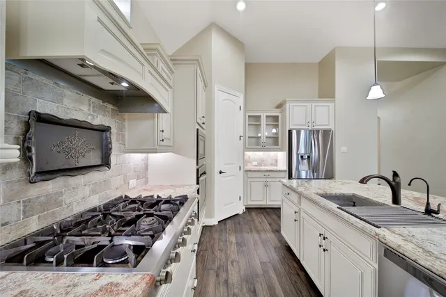 a kitchen with stainless steel appliances a stove a sink and a refrigerator