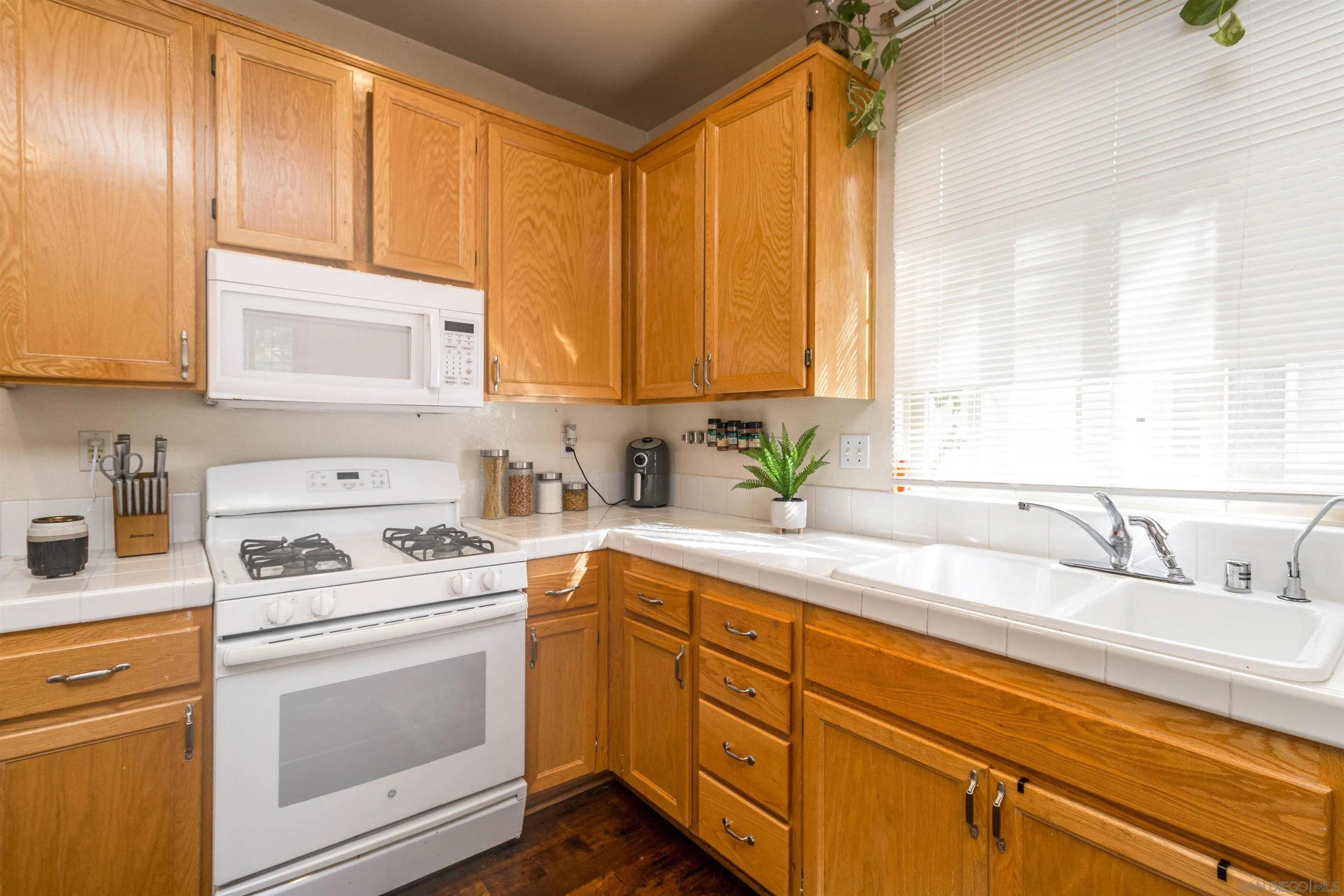 4046 Craven Road, Unit 42 Oceanside, CA 92057 - Photo 6 of 17 a kitchen with a sink cabinets appliances and a window