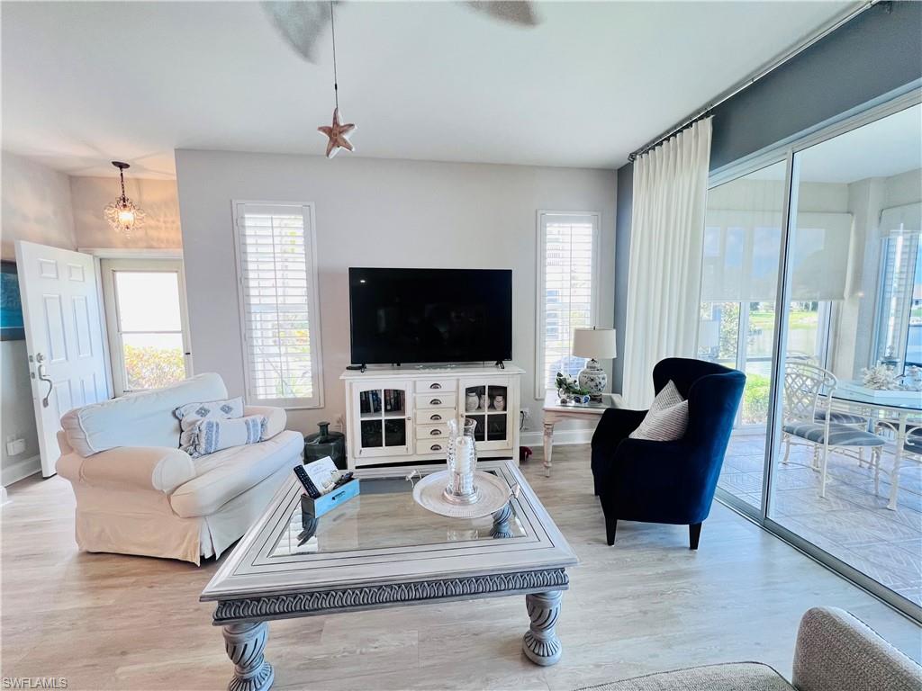 3250 West Crown Pointe Boulevard, Unit 101 Naples, FL 34112 - Photo 11 of 46 a living room with furniture and a flat screen tv