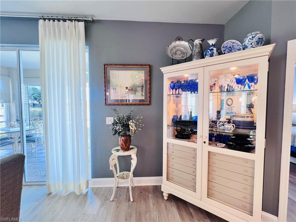 3250 West Crown Pointe Boulevard, Unit 101 Naples, FL 34112 - Photo 12 of 46 a very nice looking room with furniture and wooden floor